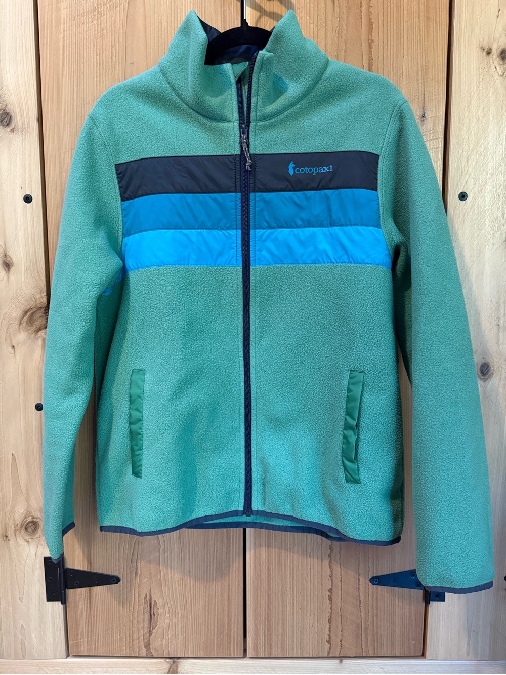 cotopaxi teal fleece jacket with blue and navy chest stripes women’s large